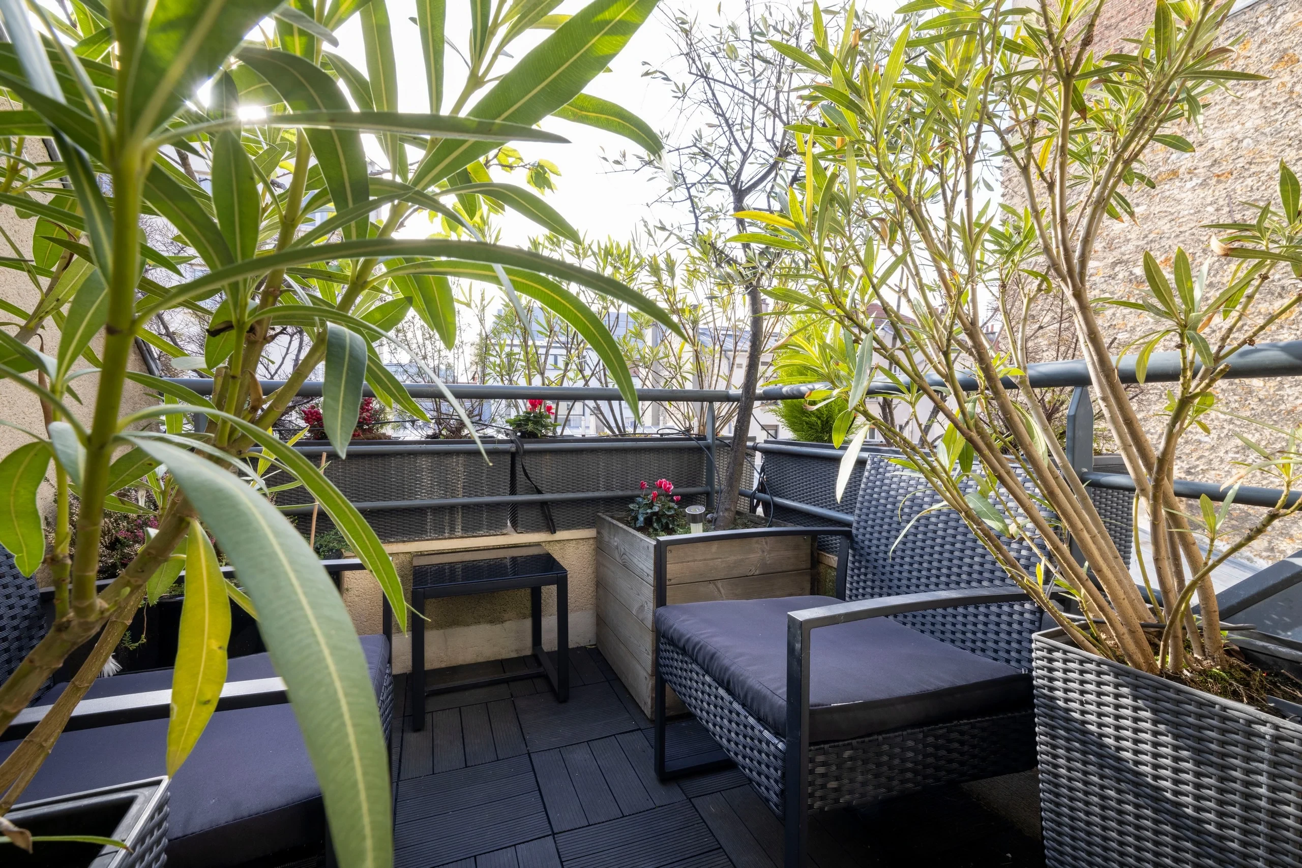 Terrasse arborée de MAISON LAVAUD - Paris, résidence hôtelière de luxe à Paris, aménagée de fauteuils.