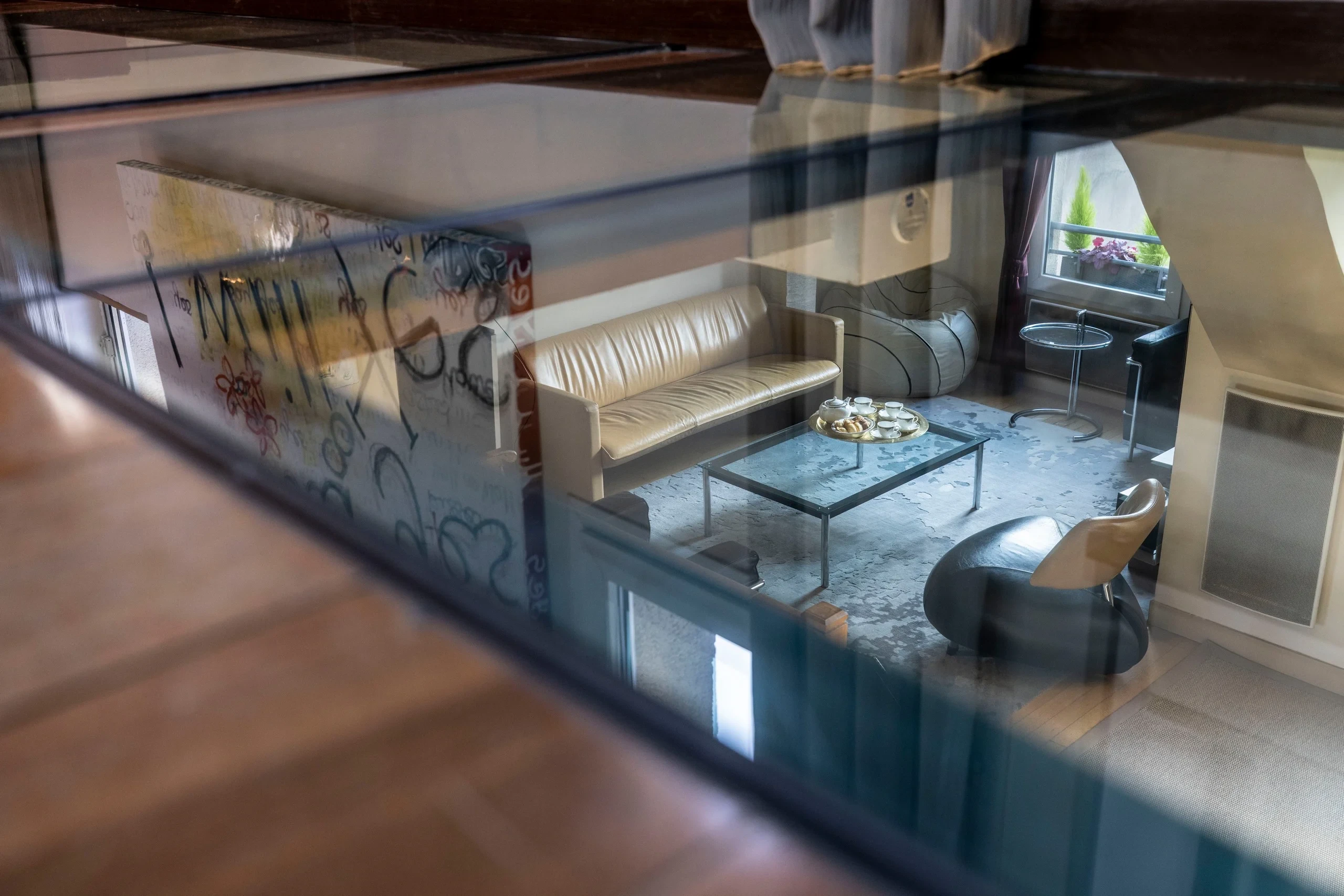 Salon vu à travers un plancher vitré dans la chambre d’hôte de luxe à Paris de MAISON LAVAUD - Paris.