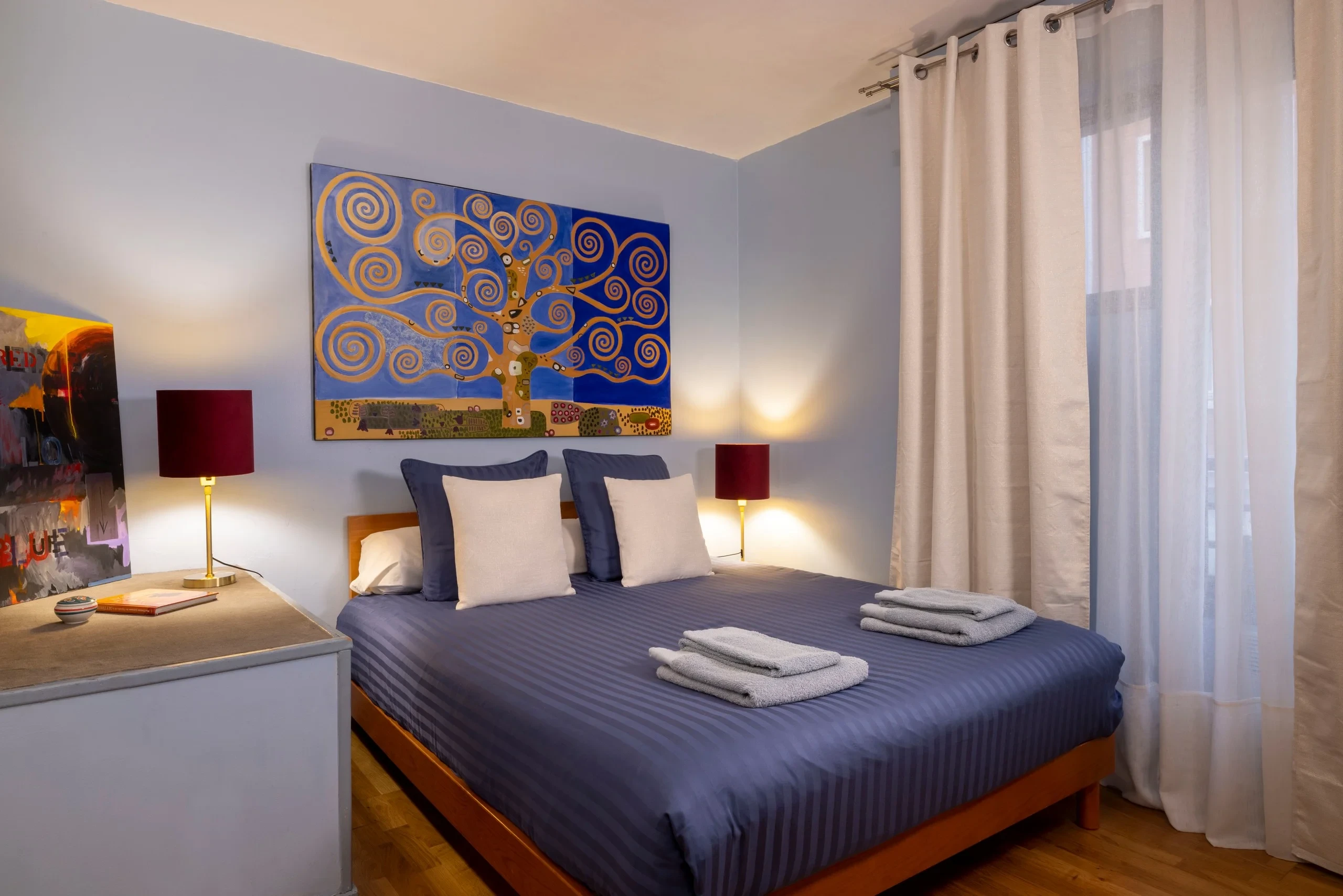 Chambre avec lit double et tableau d’arbre aux branches en spirale à MAISON LAVAUD - Paris, résidence hôtelière de luxe à Paris.