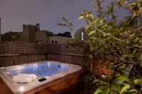 Bain à remous en terrasse au crépuscule, dans le spa privatif à Paris de MAISON LAVAUD - Paris.