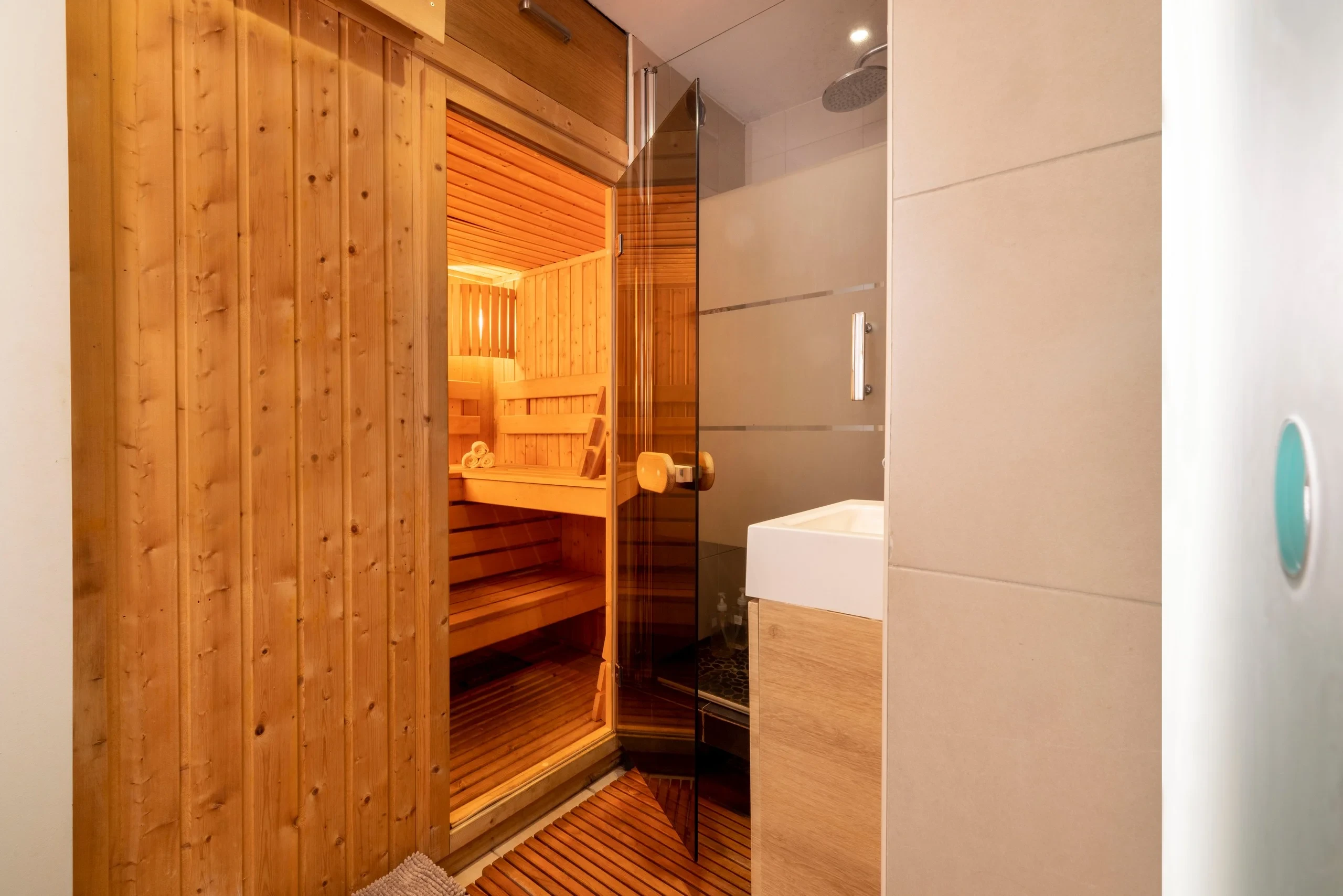 Sauna en bois et douche vitrée dans un spa privatif à Paris.