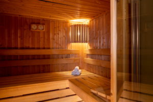 Warm wooden sauna interior with rolled towels.