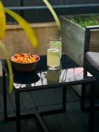 Deux boissons avec agrumes et un bol de chips sur une table de terrasse de MAISON LAVAUD - Paris.